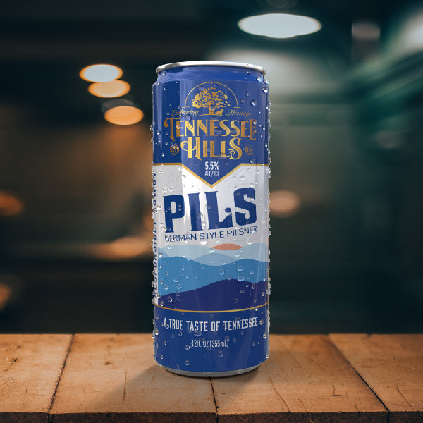 A can of Tennessee Hills Pils beer with a blue and white color scheme, featuring mountains and the Tennessee Hills logo.