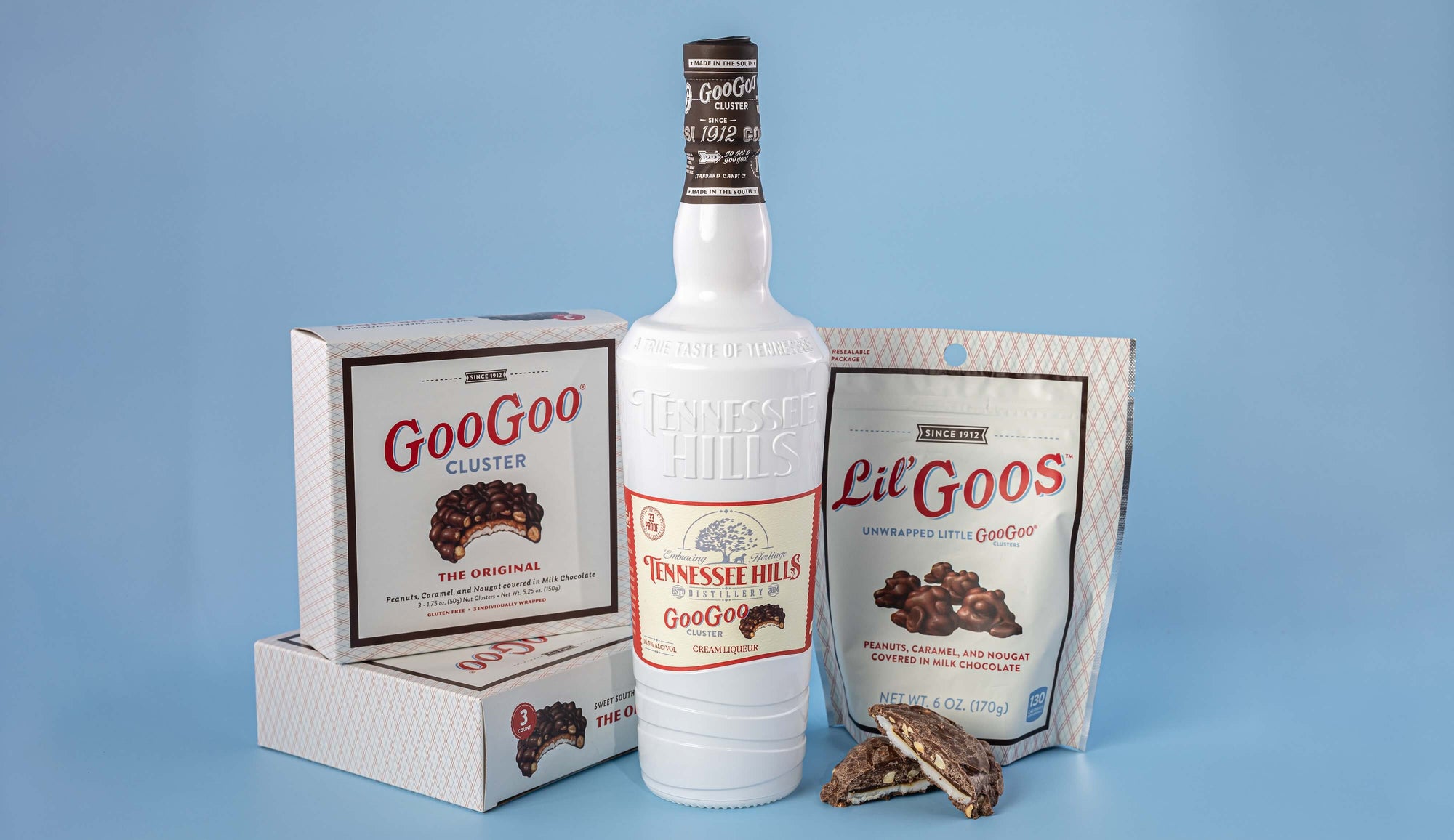 Bottle of Tennessee Hills GooGoo Cluster Cream Liqueur with Goo Goo Cluster packaging on a blue background