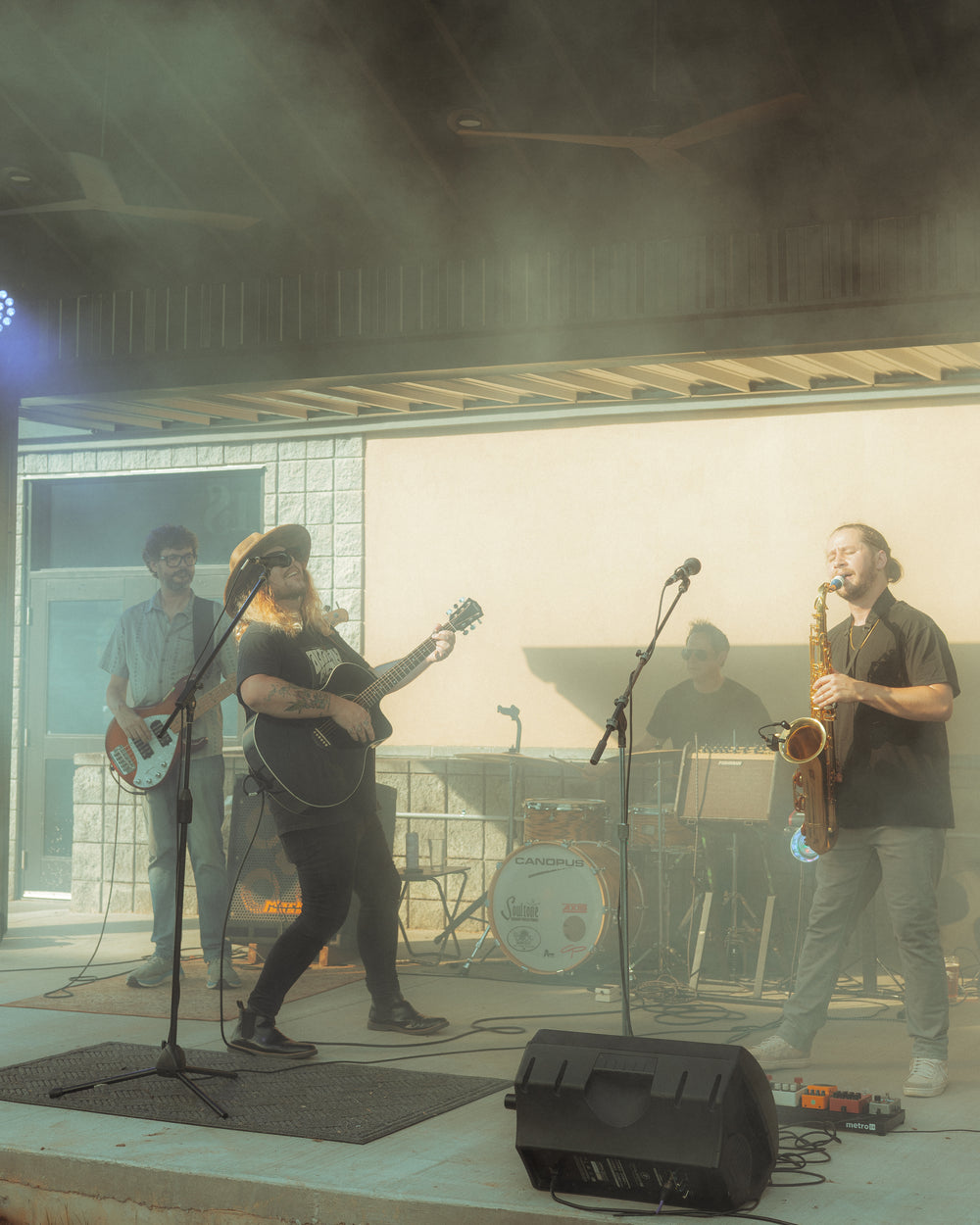 Band performing on stage with instruments and microphones.